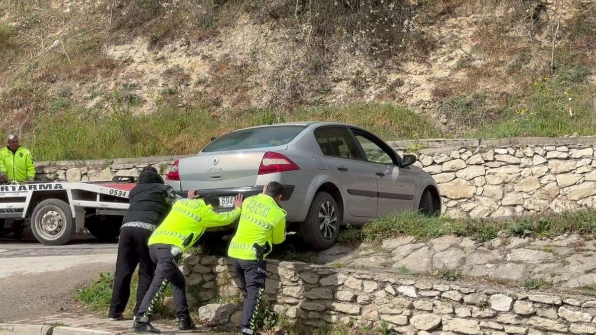 Asılı kalan otomobilini polislerin yardımıyla kurtardı